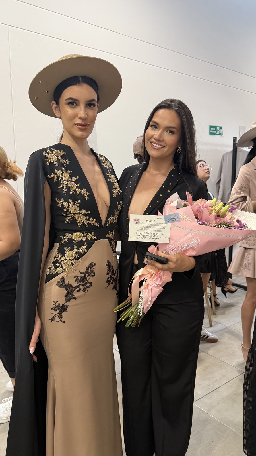 Daniela Mejía tras bambalinas junto a una modelo con un vestido de su colección
